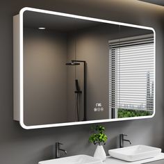 a bathroom with two sinks and a large mirror above the sink is illuminated by lights