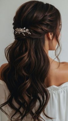 a woman with long dark hair wearing a white top and a gold leaf comb in her hair