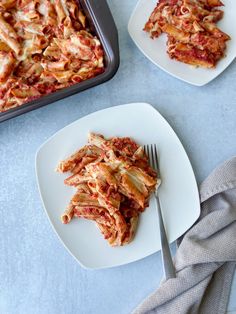 two plates with lasagna on them next to a pan of lasagna