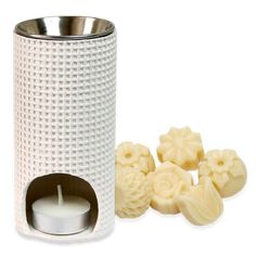 a candle and some soaps in a holder on a white background with the lid open