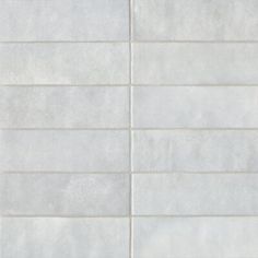 a white tile wall with vertical lines on it