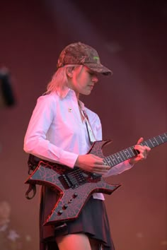 a woman playing an electric guitar on stage