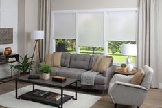 a living room filled with furniture and windows covered in shades of white blind coverings