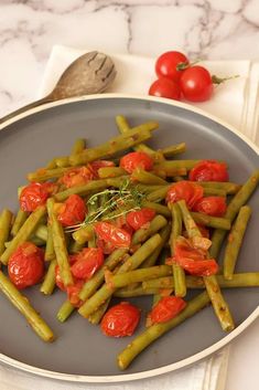 green beans and tomatoes on a gray plate