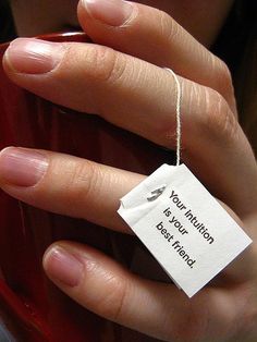 a woman's hand holding a red cup with a tag on it that says your nutrition is your best friend