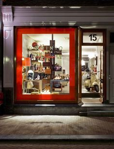 a store front at night with the lights on and motorcycles in the window, all lit up