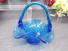 a blue glass basket sitting on top of a counter