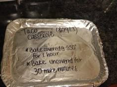 an aluminum foil covered baking pan with some writing on the top and bottom, sitting on a granite countertop