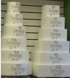 a large stack of white cakes with numbers on each tier and the words servings written on them