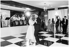 a bride and groom are dancing on the dancefloor at their wedding reception in black and white