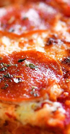 a close up view of a pizza with tomato sauce and cheese on the toppings