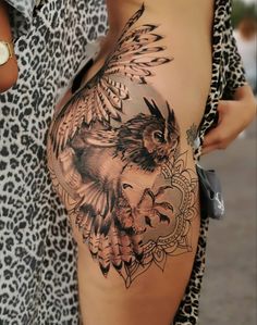 a woman's stomach with an owl and flower tattoo design on it, in front of a leopard print shirt