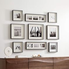 a wall with many pictures on it and a dresser in the foreground is an entertainment center