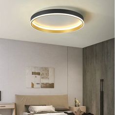 a bed room with a neatly made bed and a round light above the headboard