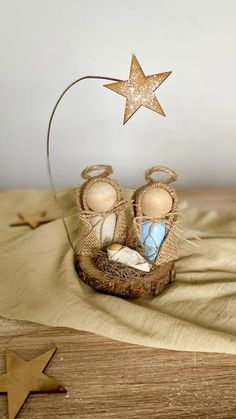 two wooden nativity figures sitting on top of a table