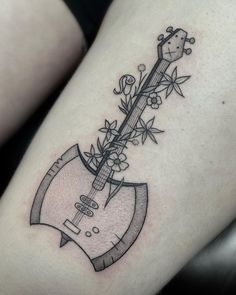 a black and white photo of a guitar with flowers on it's side thigh