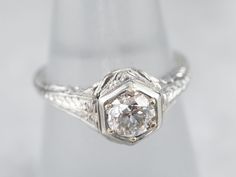 a white gold ring with an old cut diamond