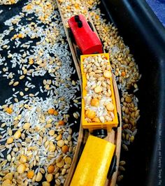 a toy train is on top of some rice and other things that are in it