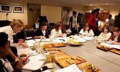 a group of people sitting around a table with papers and food in front of them