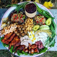 a platter filled with meats, vegetables and other foods