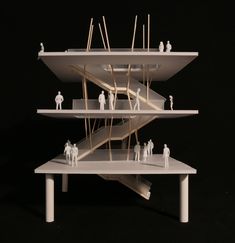 three tiered structure with miniature people standing on each side and one man in the middle