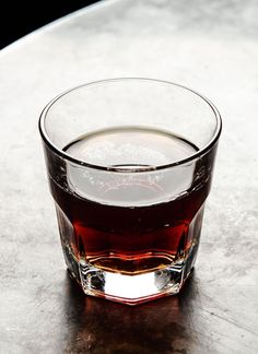 a glass filled with liquid sitting on top of a table