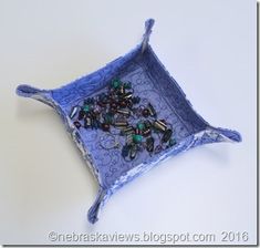 a blue tray with beads on it sitting on a table