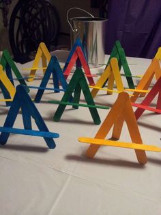 a group of colorful wooden sticks sitting on top of a white tablecloth covered table