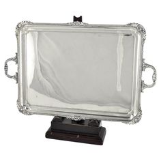 an ornate silver plated mirror on a wooden stand with a black base and white background