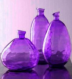 three pink glass vases sitting on top of a white table next to each other