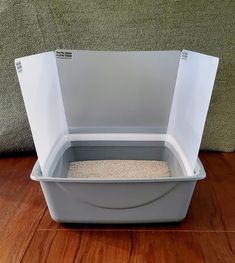 a cat litter box on the floor with its lid open to show it's inside