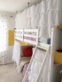 bunk beds with white ruffle curtains and yellow walls in a child's bedroom