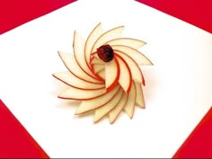 an apple sliced in half and sitting on top of a piece of white paper with a red background