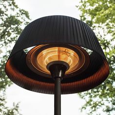 an outdoor heater sitting on top of a metal pole