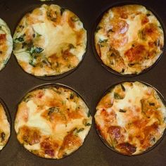 six mini pizzas sitting in a pan on top of a stove burner with cheese and spinach toppings