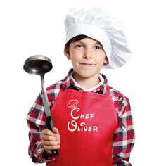 a young boy wearing an apron and chef hat holding a spatula