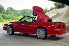 a red convertible car with its hood open