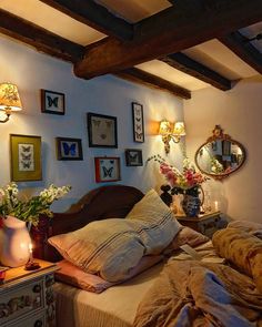 a bed room with a neatly made bed and lots of pictures on the wall above it