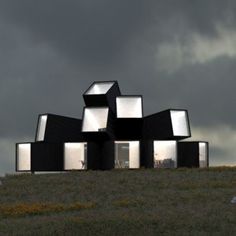 a black and white house sitting on top of a lush green hillside under a cloudy sky