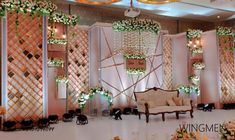 an elaborately decorated stage set up with flowers and greenery for a wedding reception