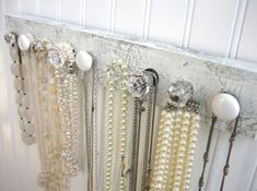 there is a rack with pearls and beads hanging on the wall next to a door