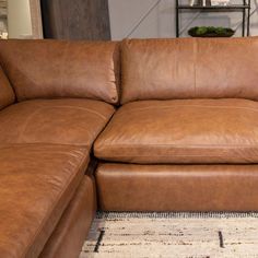 a large brown leather couch sitting on top of a rug