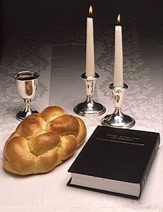 the bread is next to three candles and a book