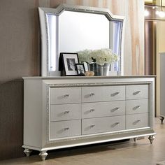 a white dresser and mirror in a room