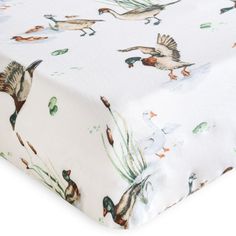 a white sheet with ducks and plants on it