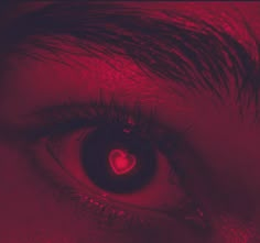 a person's eye with red light shining in the center and heart on it