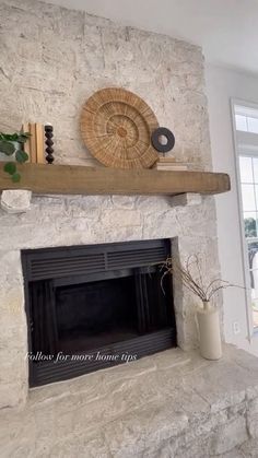 a living room with a stone fireplace and white walls