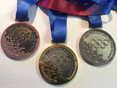 three olympic medals with blue ribbons around them