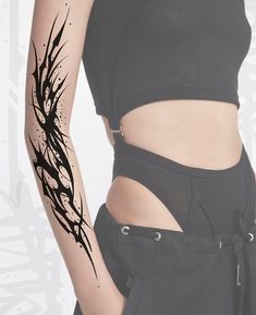 a woman's arm with black ink splattered on it and a tattoo design