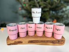 a wooden tray with pink cups on it